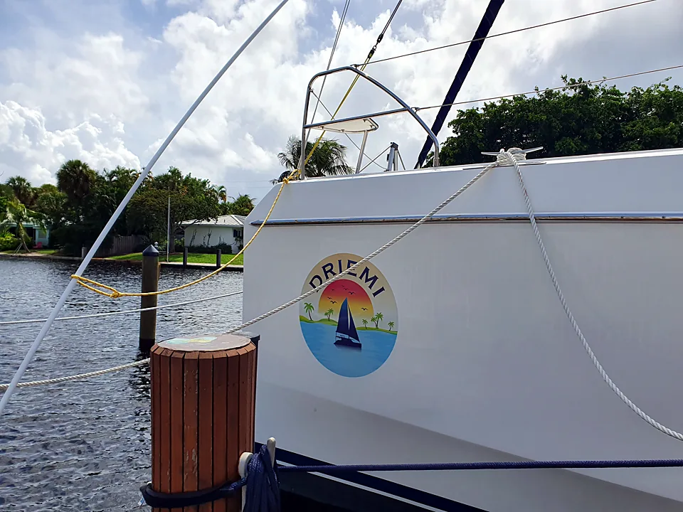 The Driemi logo on the white hull, tied up at the dock
